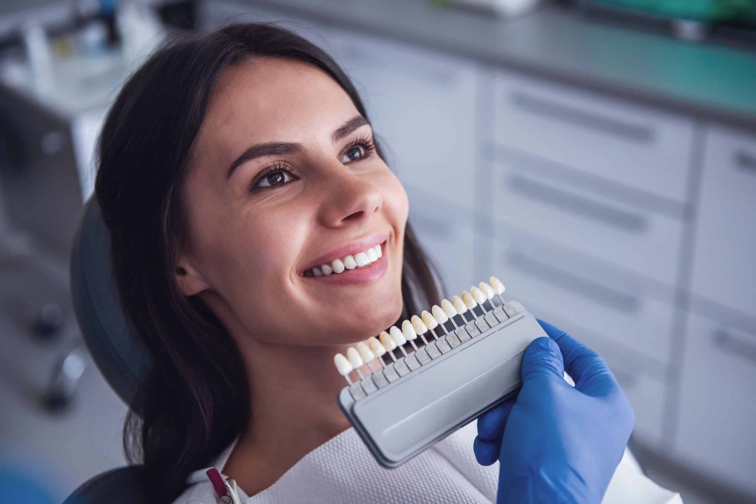 The woman is getting a new of veneers, so she is analyzing her shade