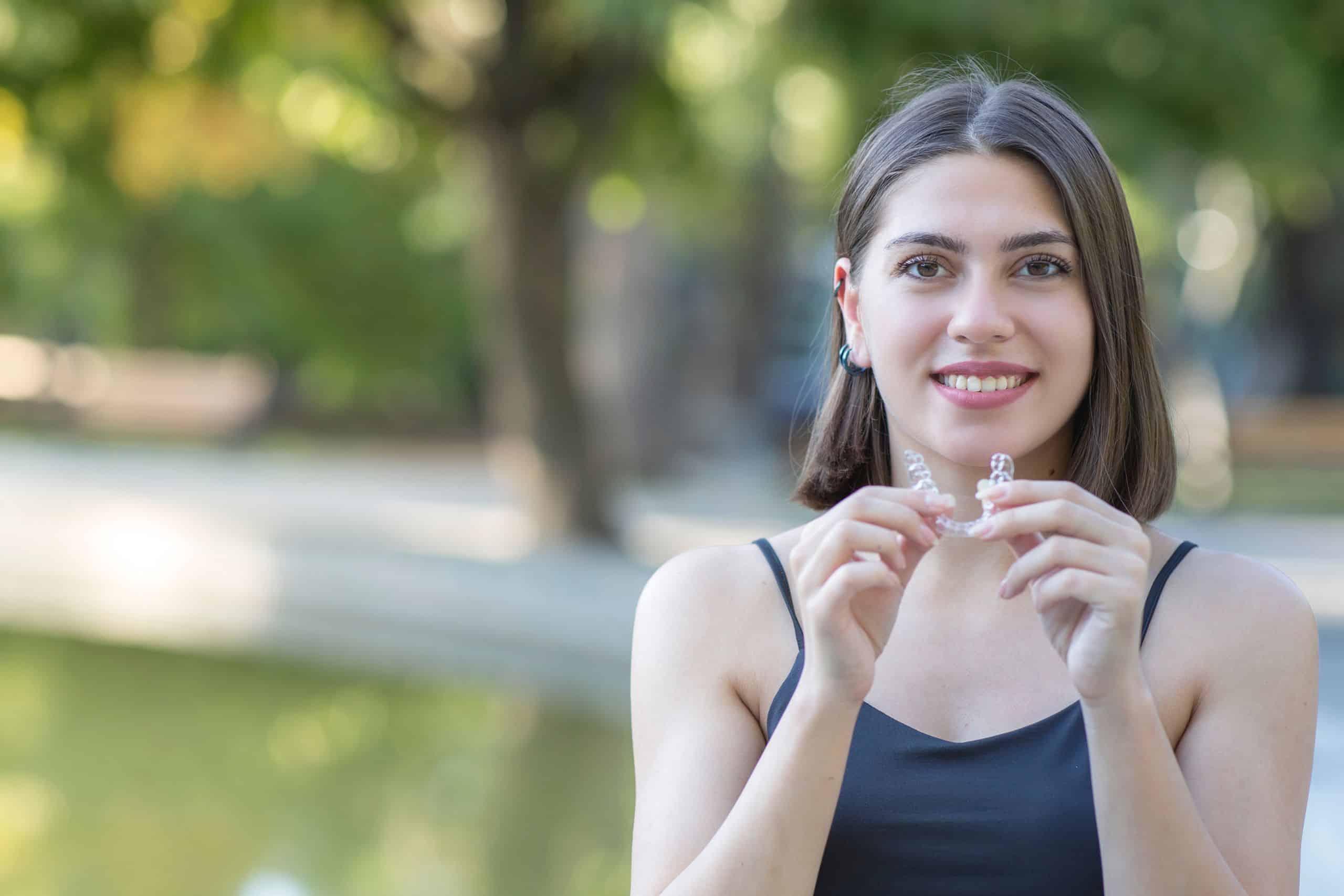 The woman is happily showcasing her Invisalign.